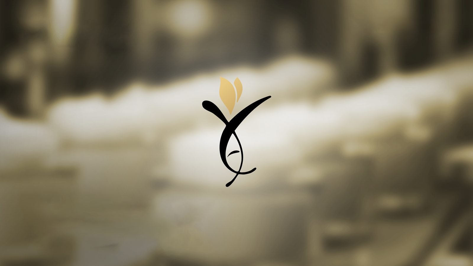 The Al Enayah Al Kamlah mark — a black calligraphic form with gold petals, over the production floor